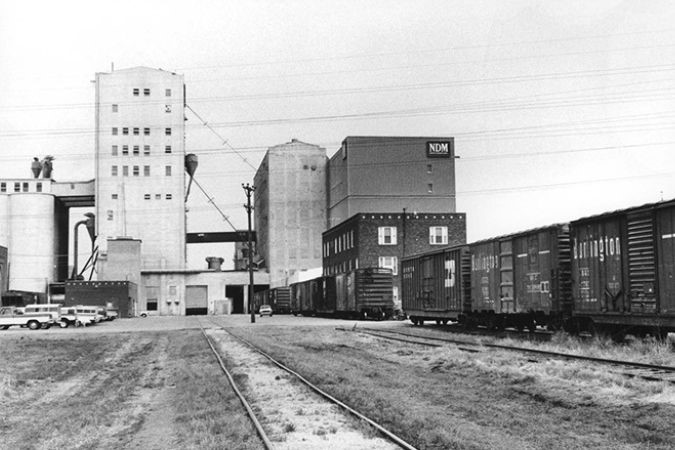 Rail cars with markings of BNSF predecessors Burlington Northern (BN) and Chicago, Burlington & Quincy Railroad (CB&Q) outside the mill in an undated photo taken 1970 or later.